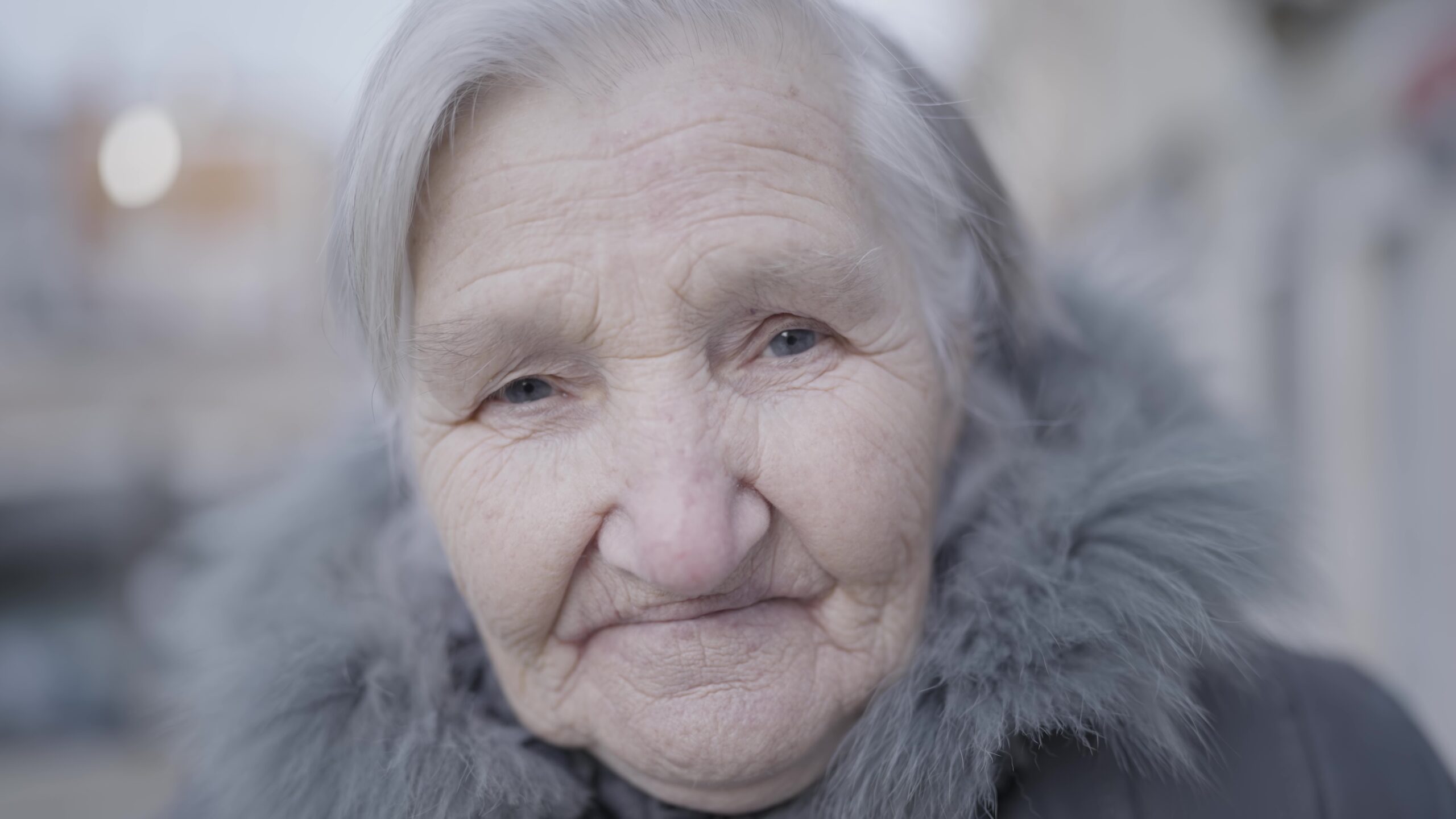Elderly lady in fur coat, with a joyful smile and wrinkled cheeks