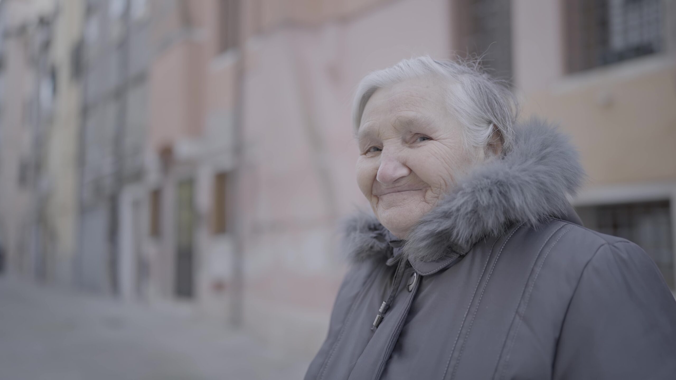 Elderly woman in city street amidst buildings
