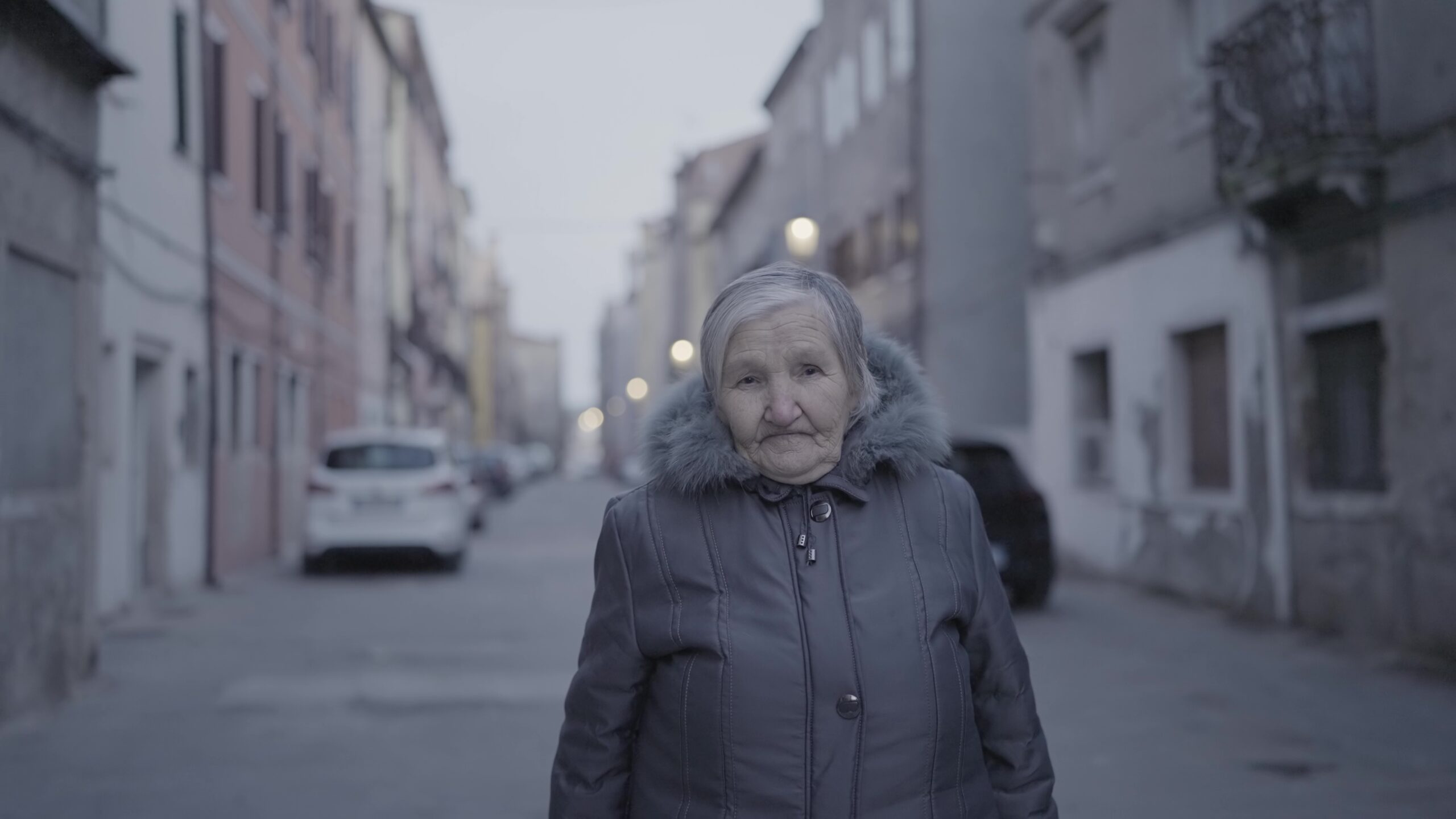 Elderly woman is standing in a city street
