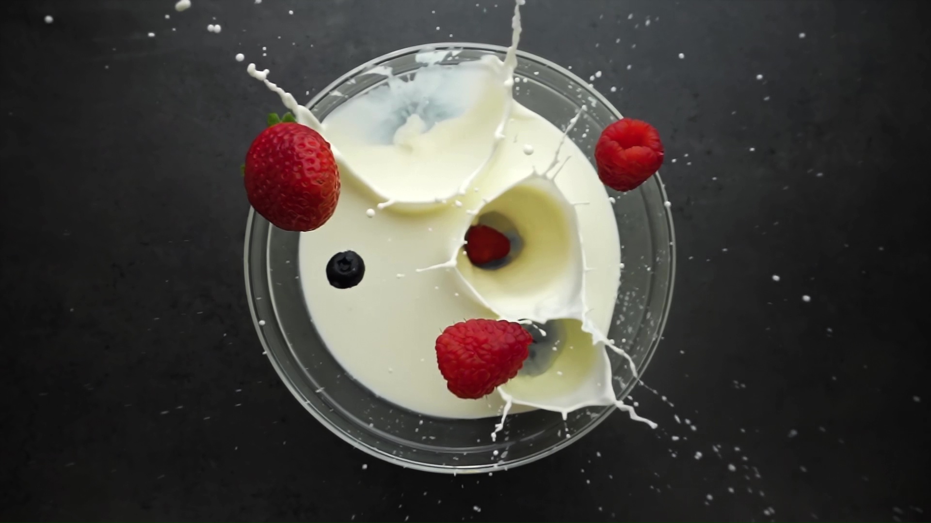 Frutta che spruzza nel latte al rallentatore
