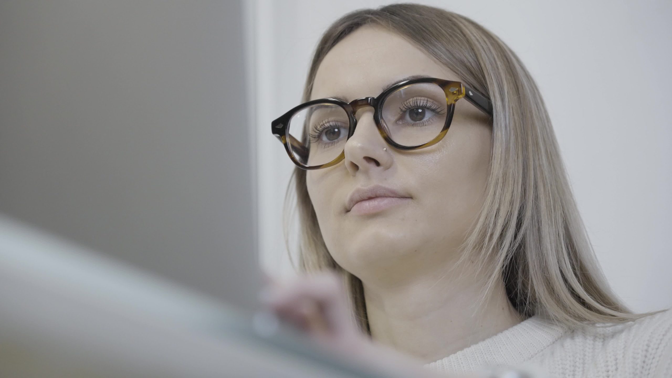 Una donna che indossa gli occhiali usa un computer portatile