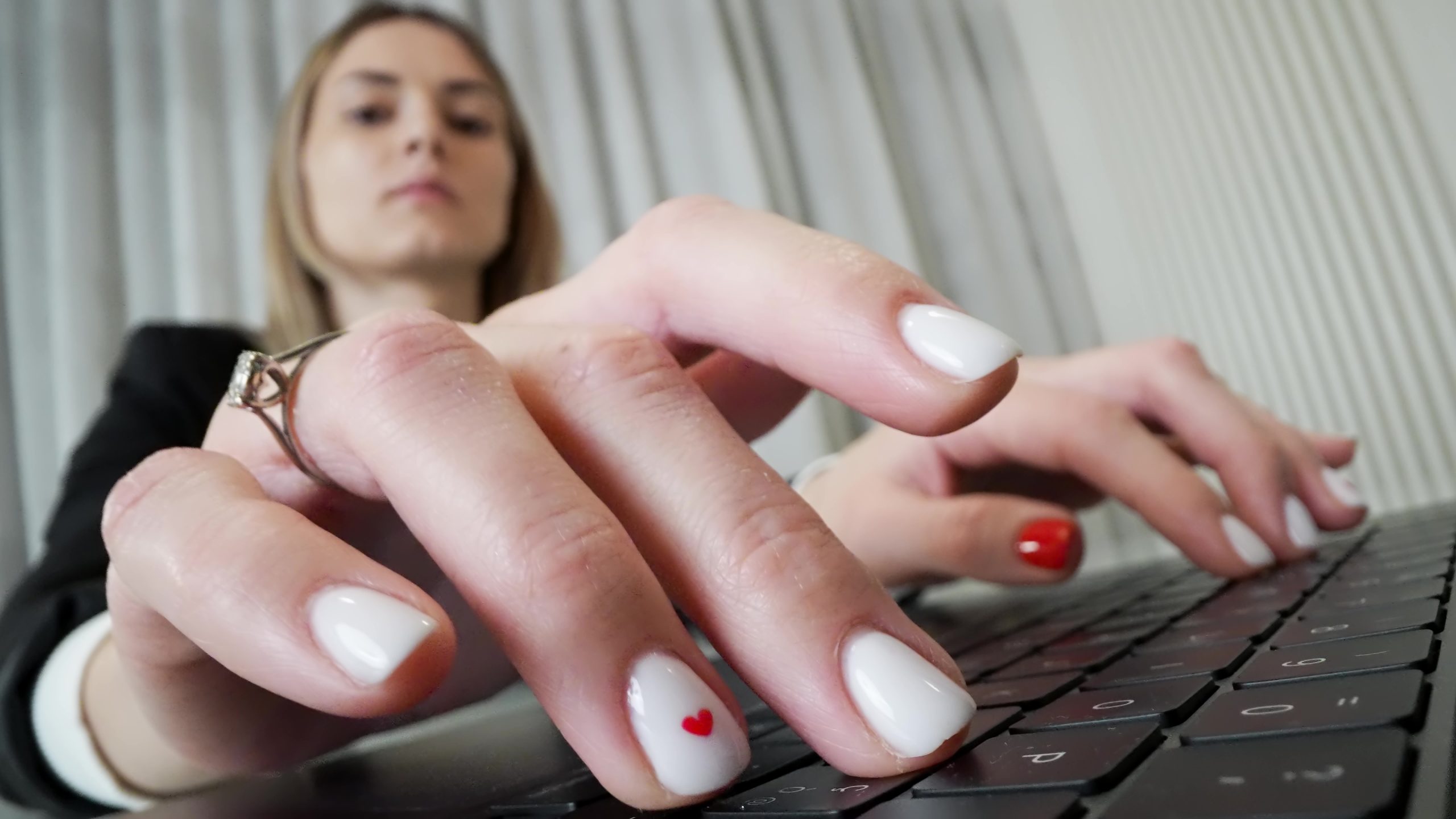Le dita della donna in ufficio che digitano sulla tastiera del computer