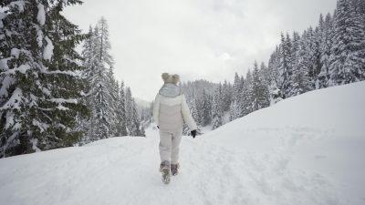Woman slips and falls on the snow in the woods
