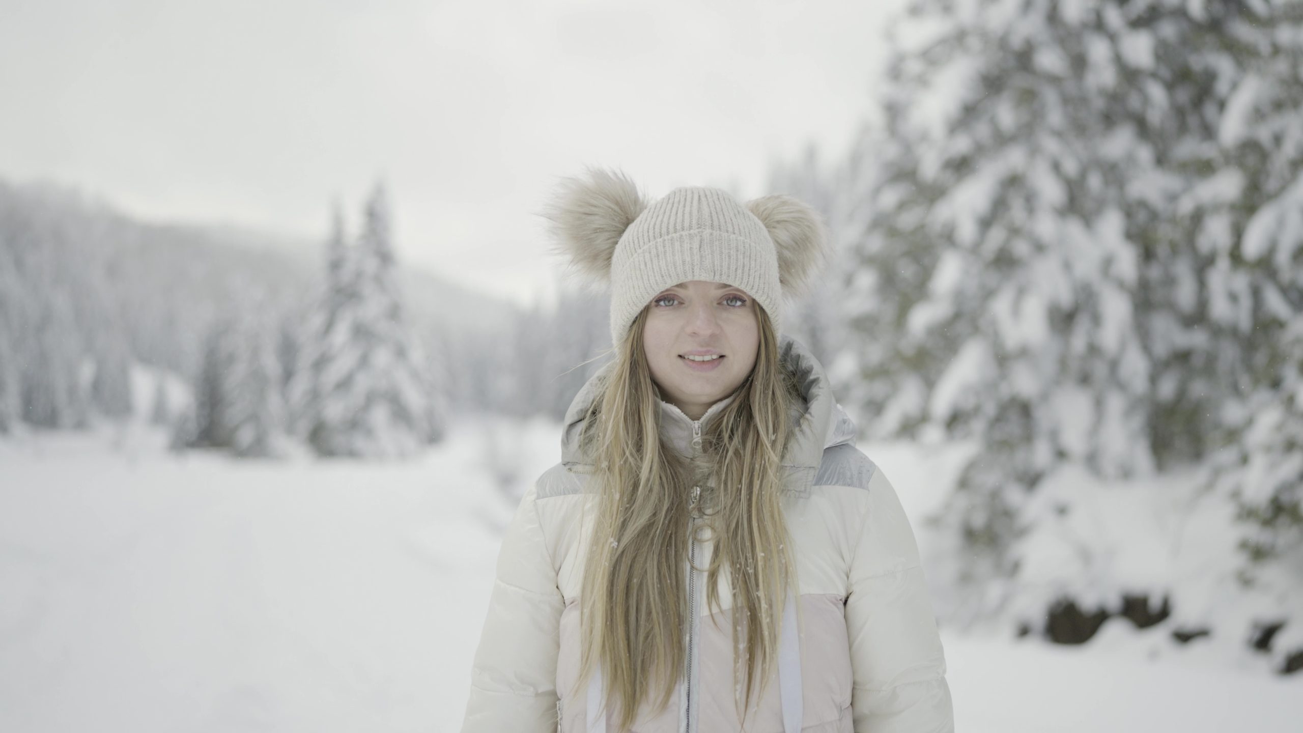 Face of the woman smiling still in winter among the trees of the forest