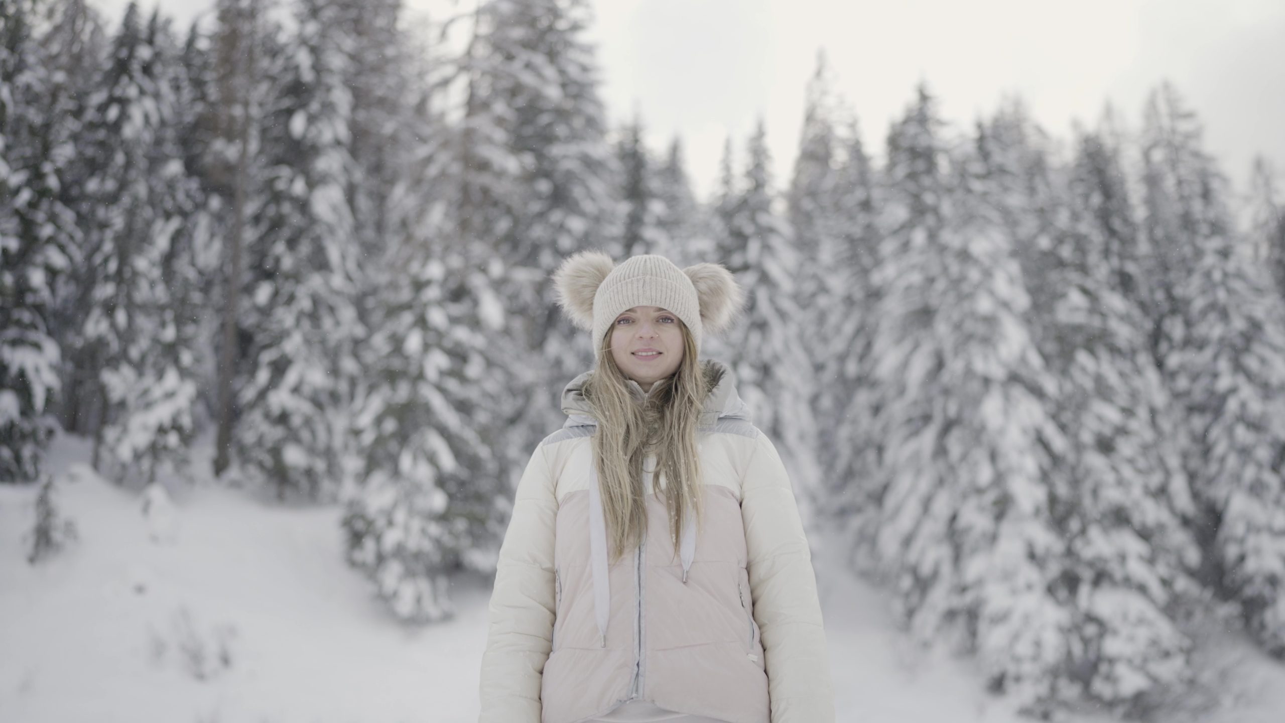 Donna sorride davanti alberi con la neve