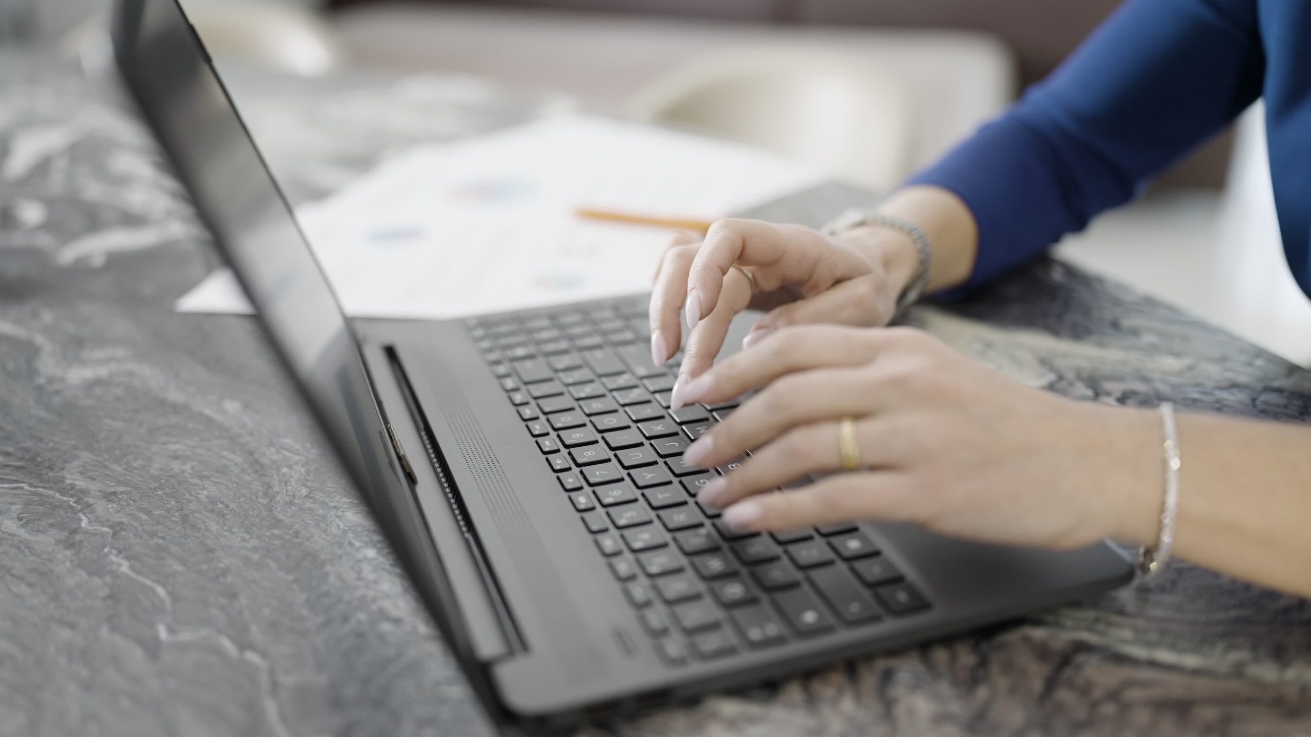 Mani della donna digitano sulla tastiera del computer portatile