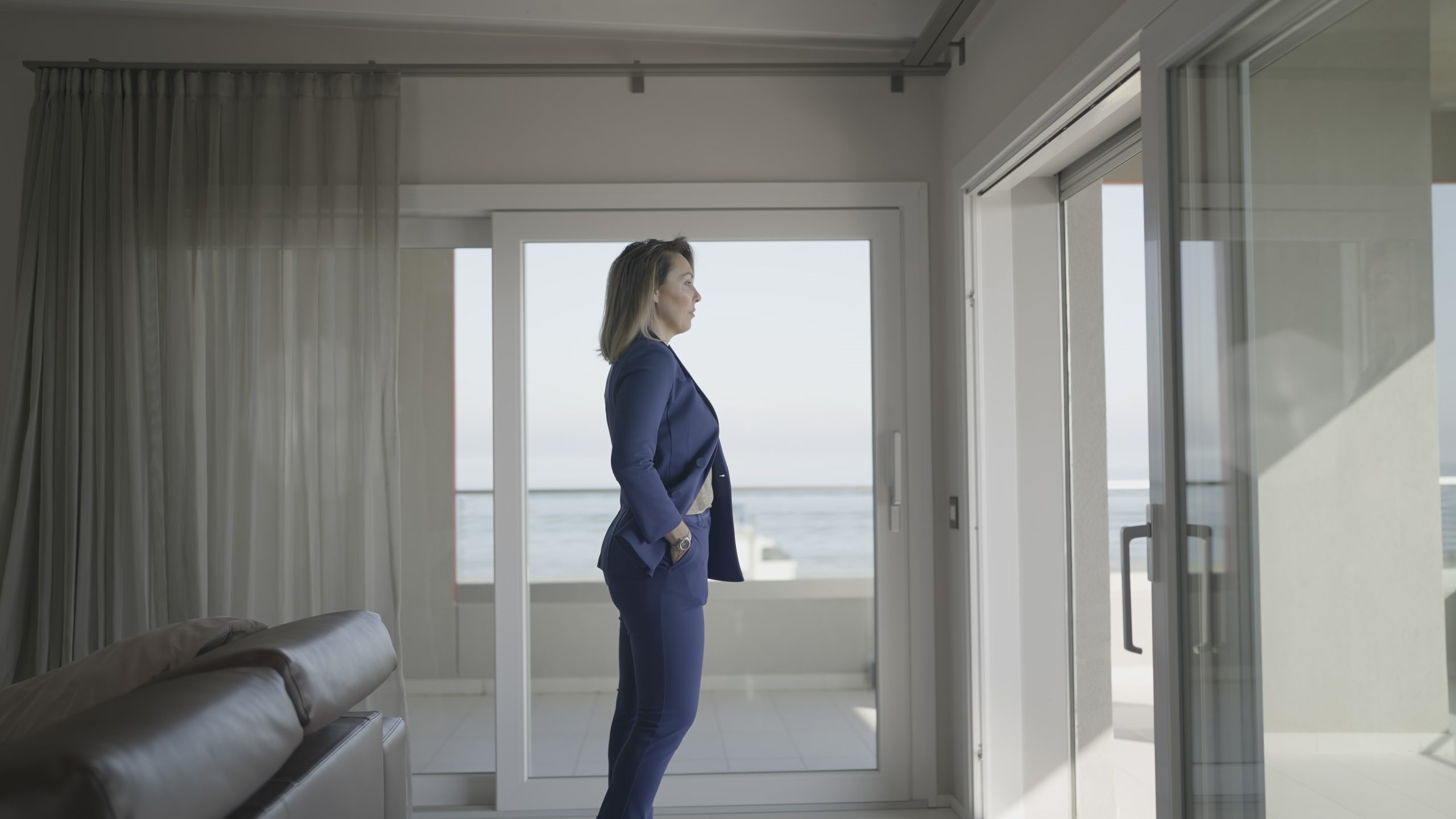 Donna vestita seria guarda nelle finestre dell’ufficio