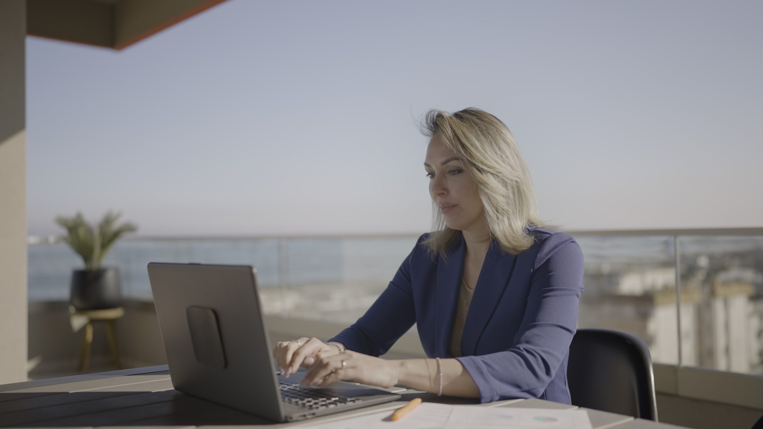 Donna lavora al computer portatile sul poggiolo
