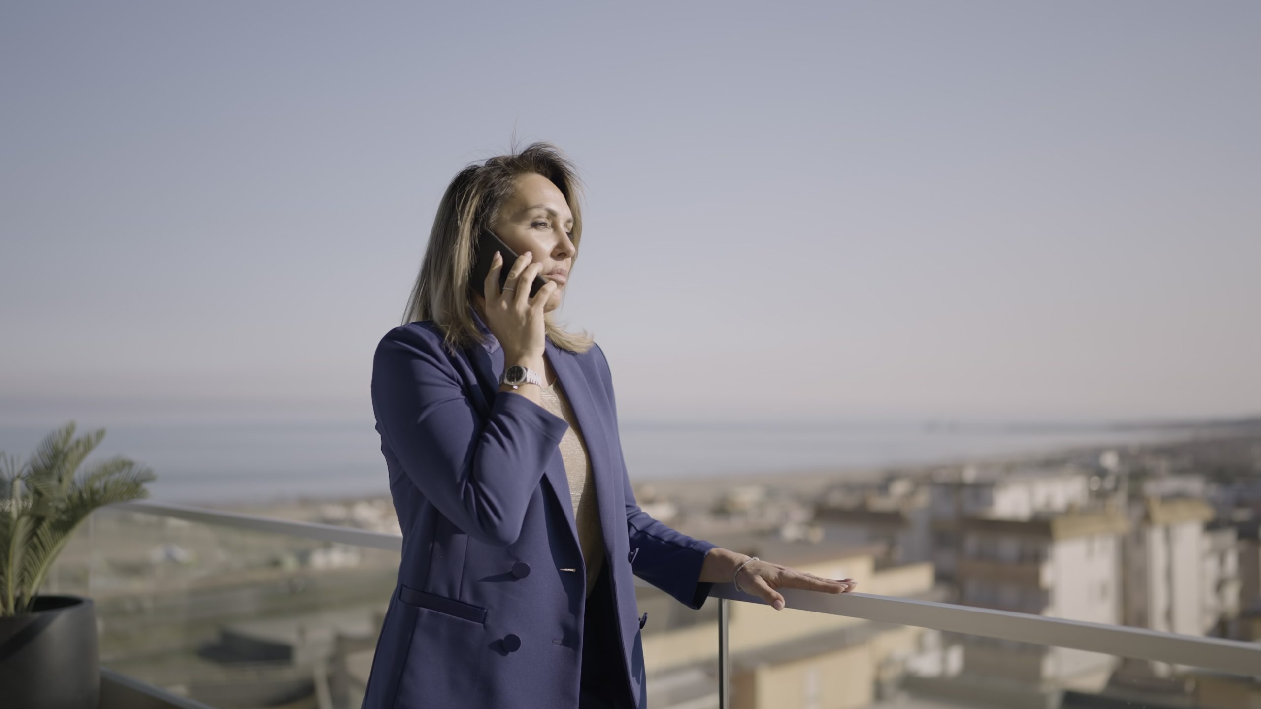 Donna professionale esce sul balcone parlando al telefono