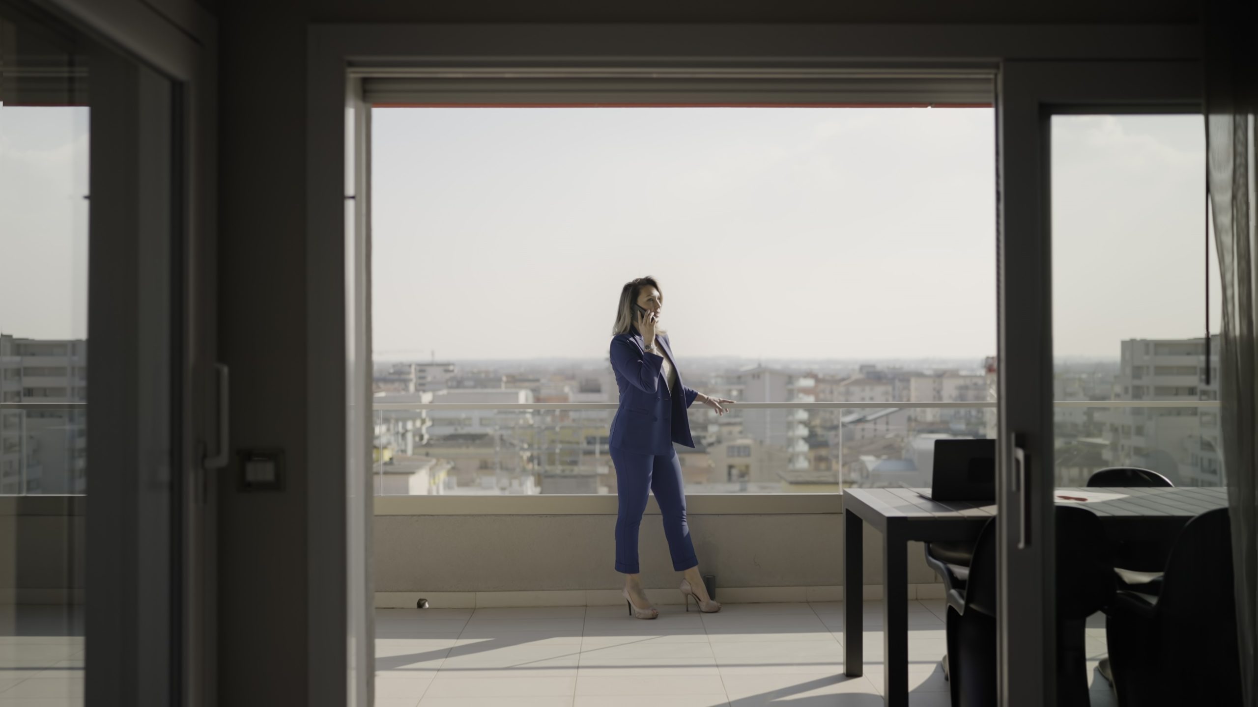 Donna parla al telefono fuori dall’ufficio