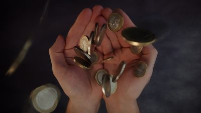 Coins fall into the palms of the hands