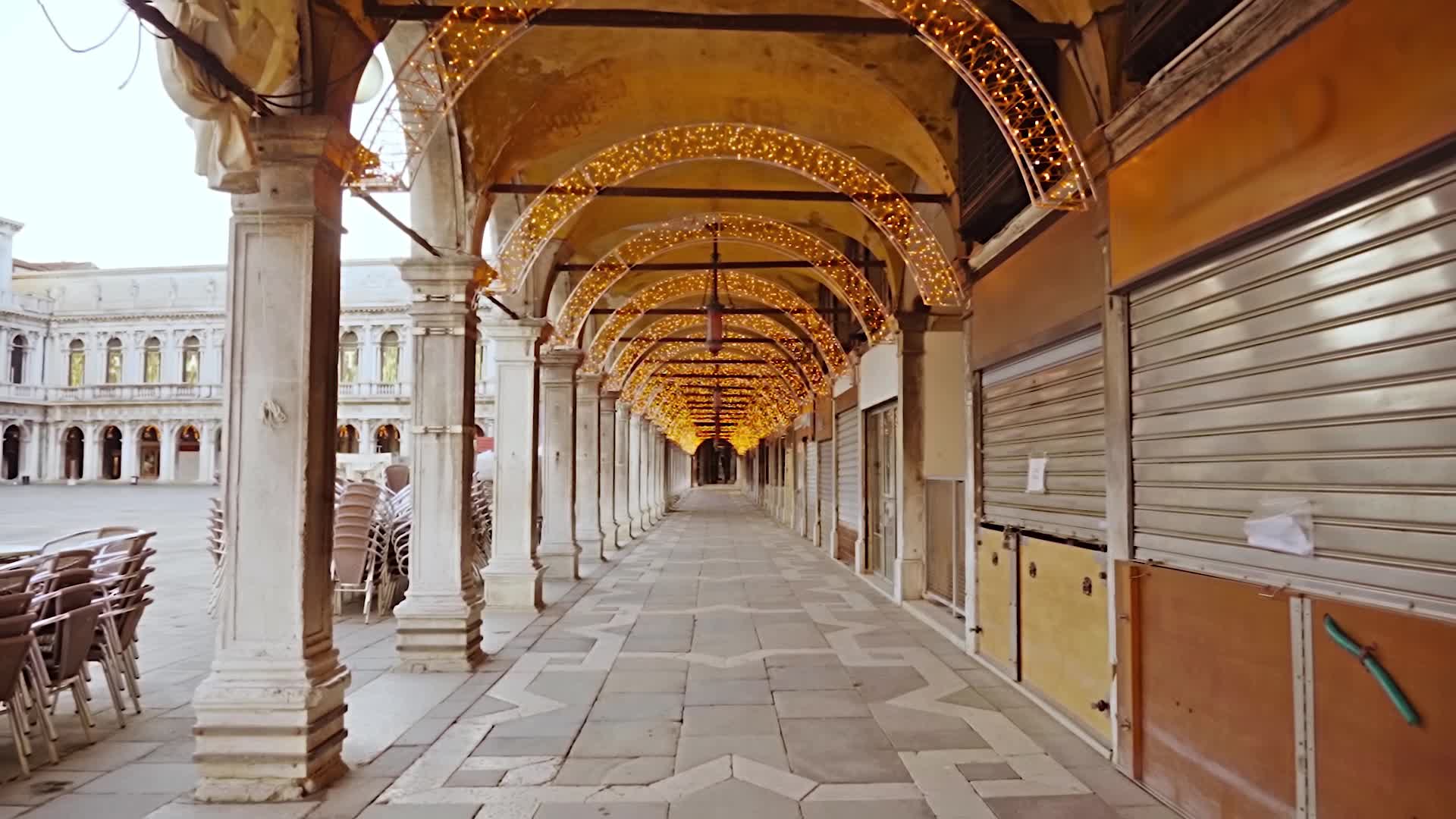 Movimento lungo il passaggio ad arco illuminato da luci decorative con negozi chiusi