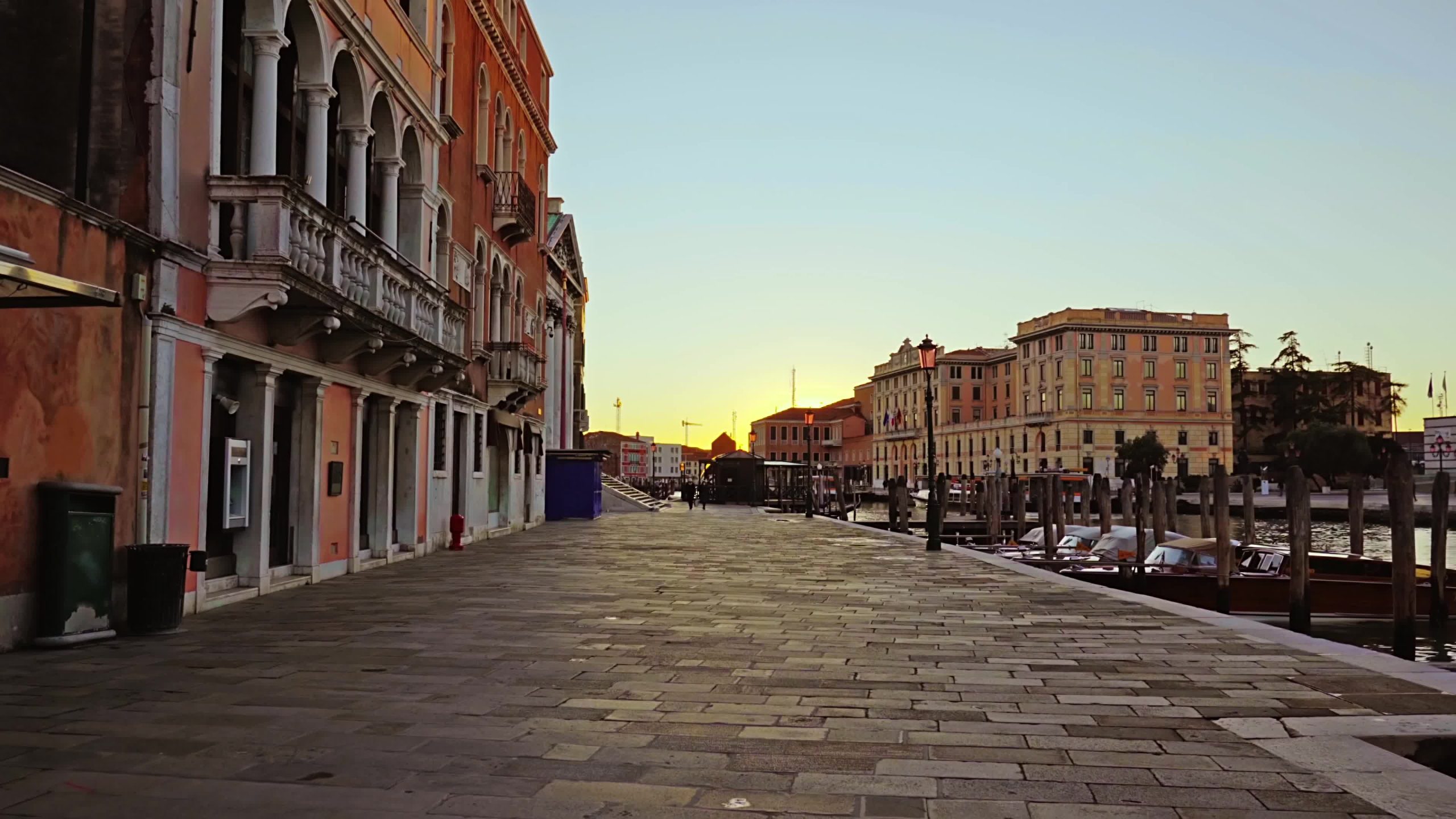 Movimento lungo il lungofiume vuoto con barche ormeggiate accanto a edifici storici ed eleganti