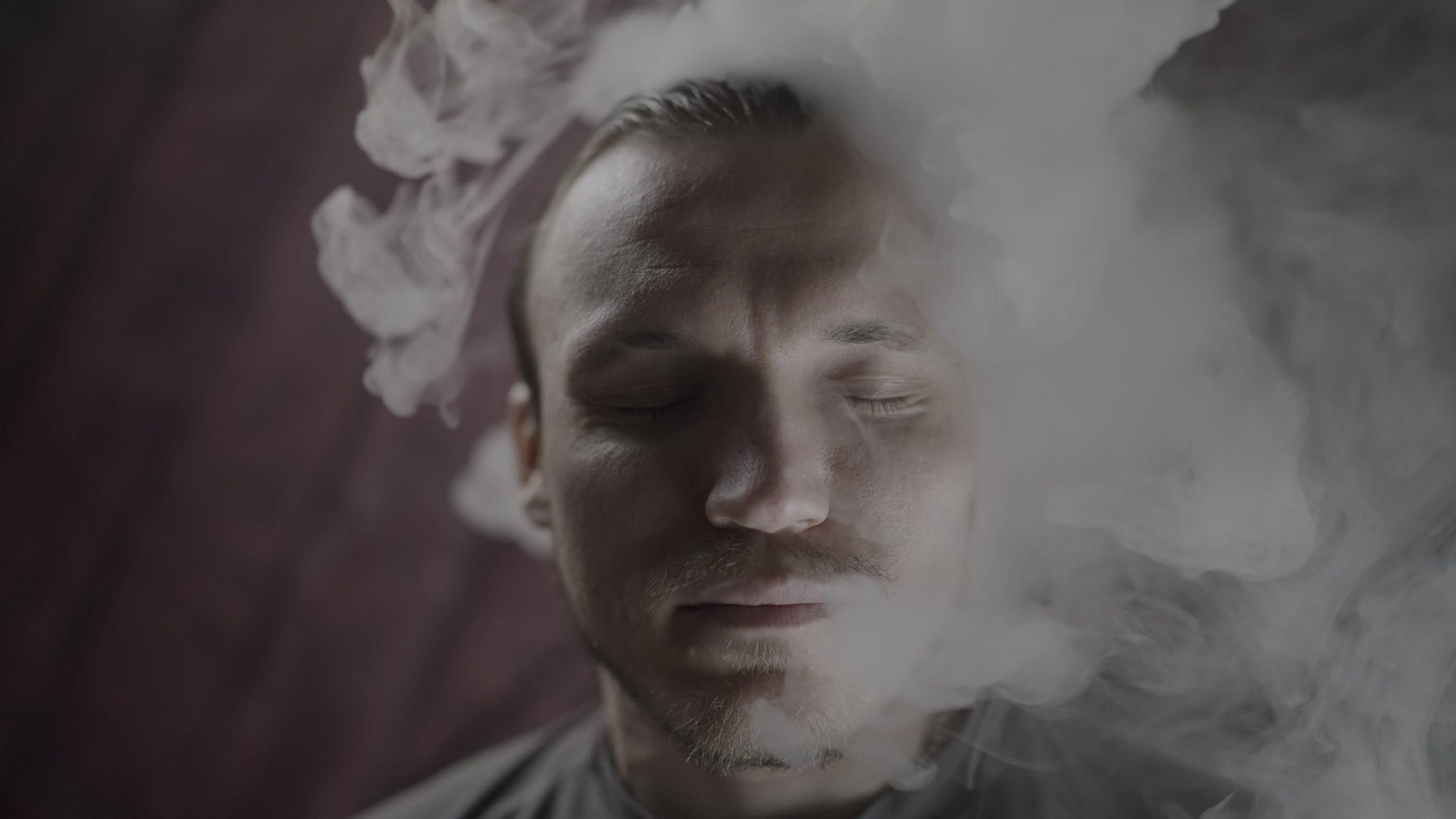 Viso di uomo circondato da fumo con occhi chiusi