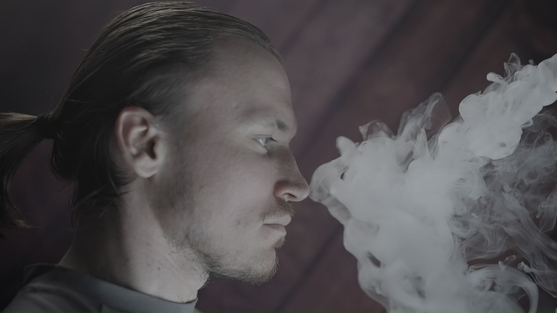 Man Exhaling Smoke in Profile