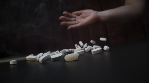 Spilled Pills on Dark Surface