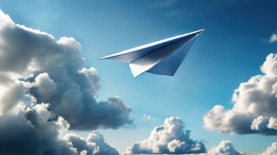Aereo di carta che vola tra le nuvole