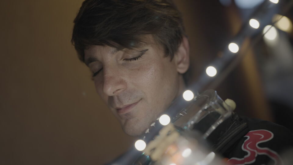 Uomo che suona il violino sotto luci soffuse
