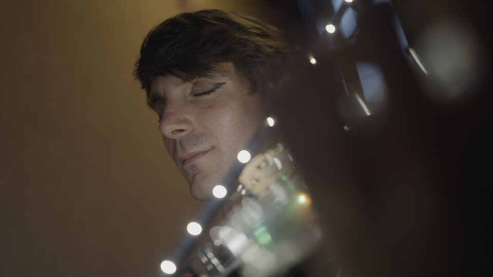 Man in deep focus playing violin under soft lights