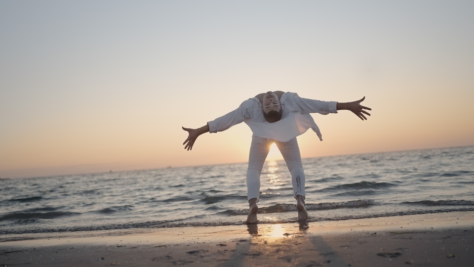 Expressive Dance Pose on the Beach at Sunset