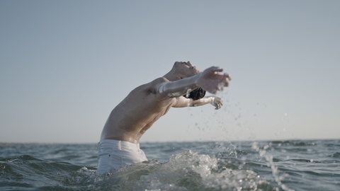 Persona che emerge dall’acqua con le braccia distese