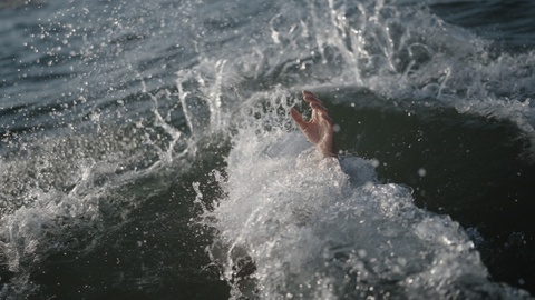 Hand Reaching Out of a Wave in the Ocean