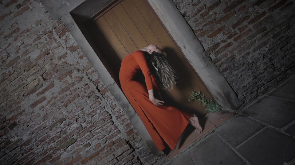 Dancer in Red Arching Back Against Brick Wall