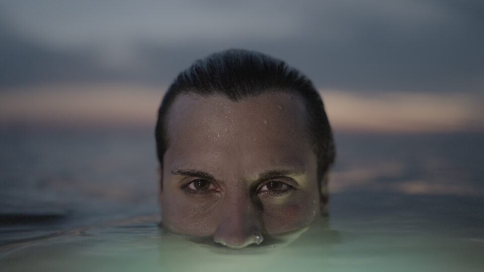 Sguardo intenso che emerge dall’acqua al crepuscolo