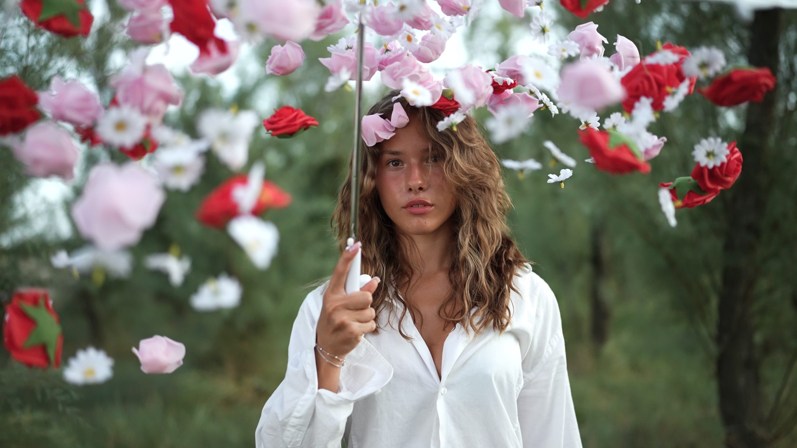 Donna circondata da fiori cadenti nella natura