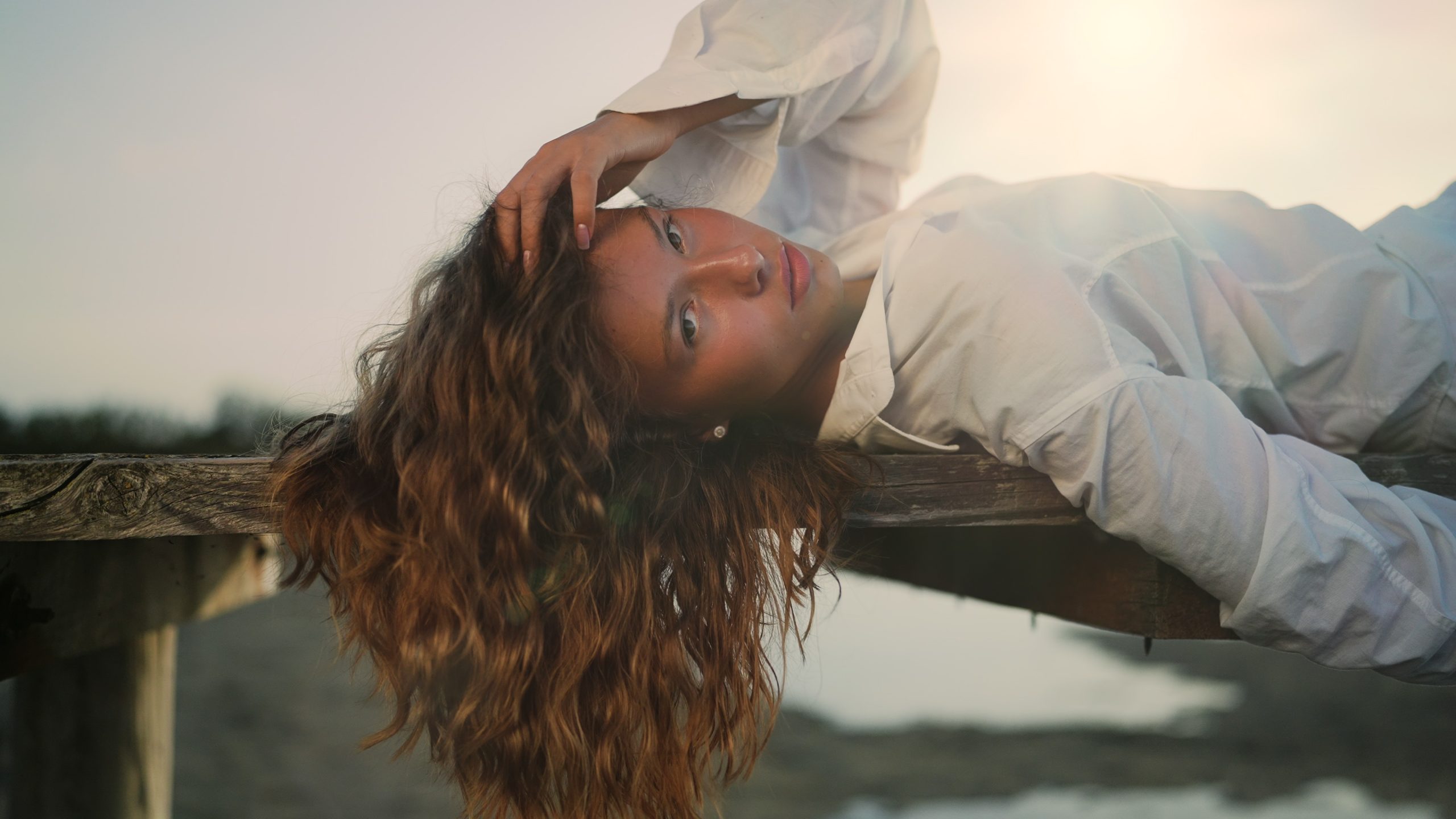 Woman Relaxing on Wooden Pier at Sunset