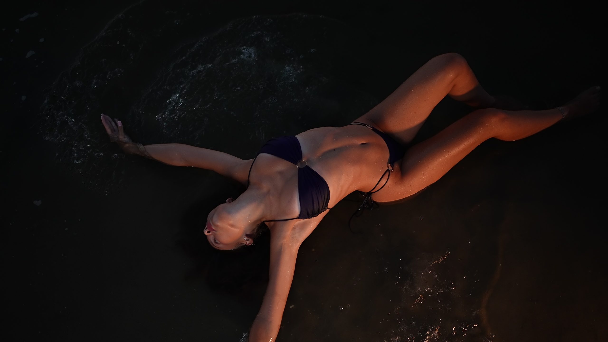 Woman Floating Peacefully in Dark Water at Night