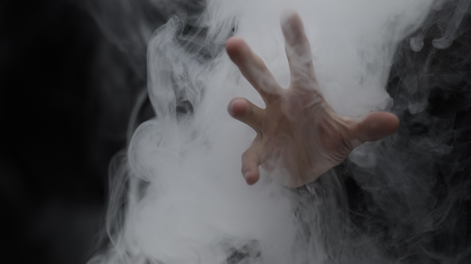Hand reaching through swirling mist
