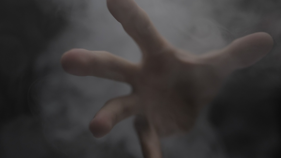 Hand reaching out through mist