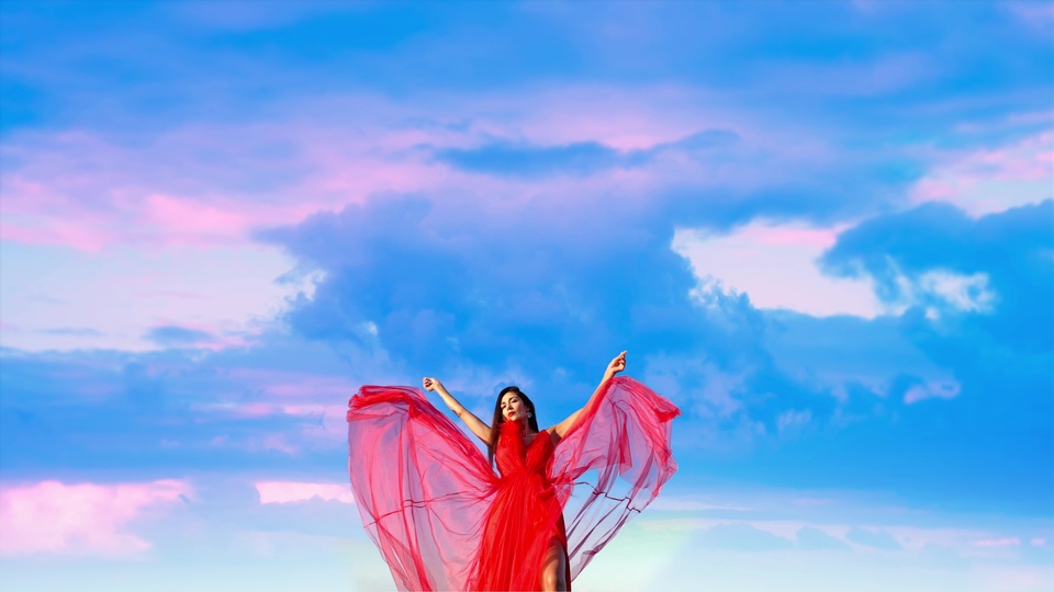 Donna in Abito Rosso Sotto un Cielo Vibrante