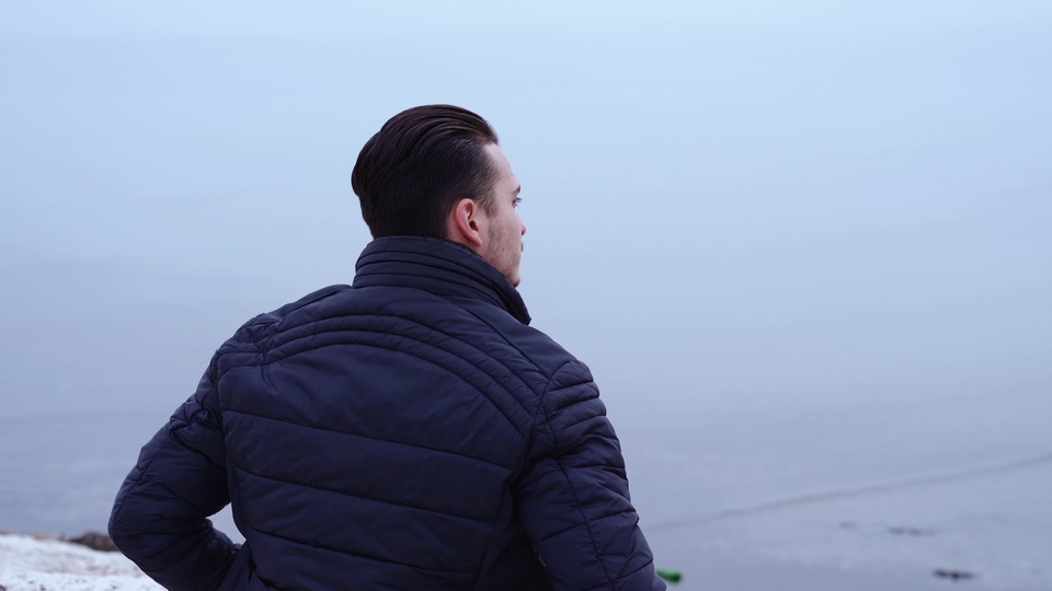 Uomo che guarda un paesaggio marino nebbioso