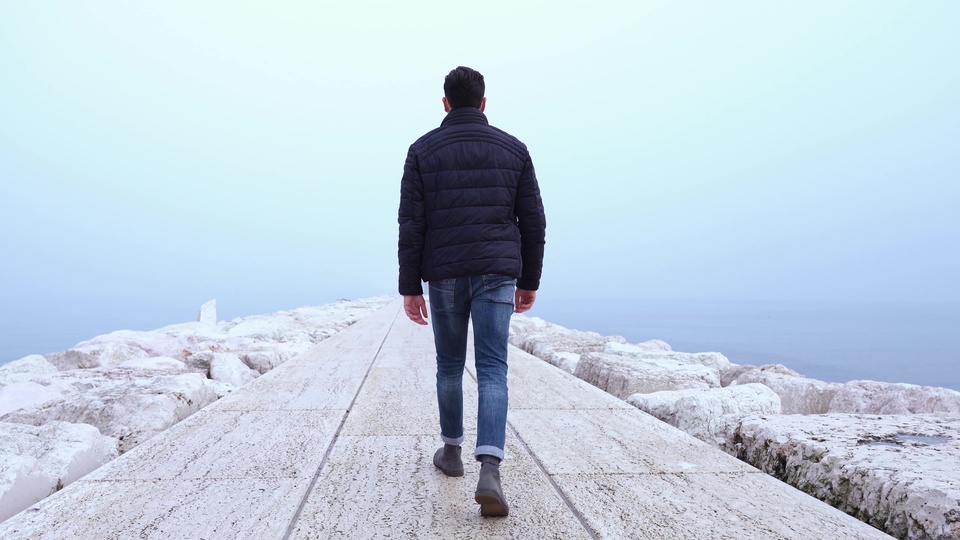 Man Walking Alone on a Misty Pier